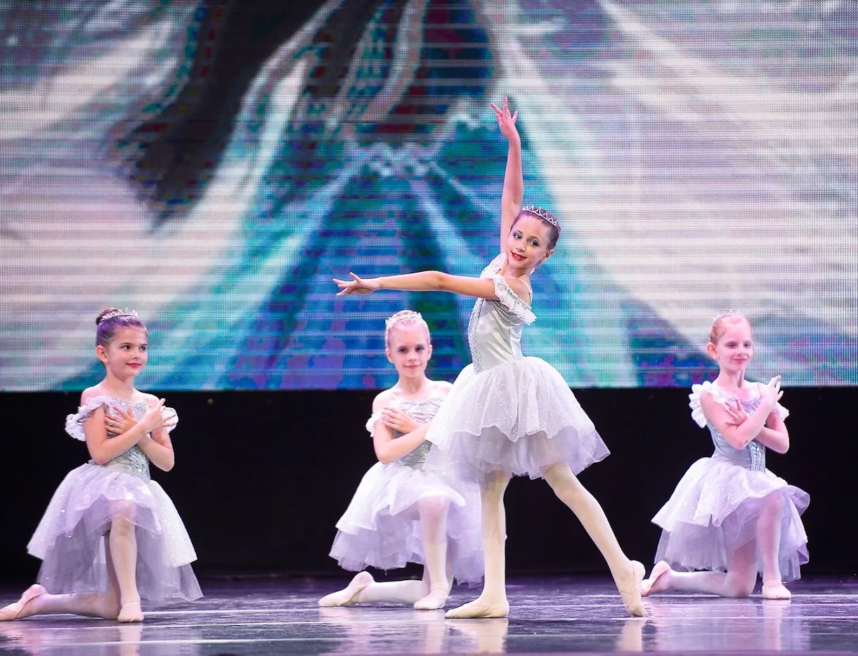 Nika Ballet students in white tutus performing on stage