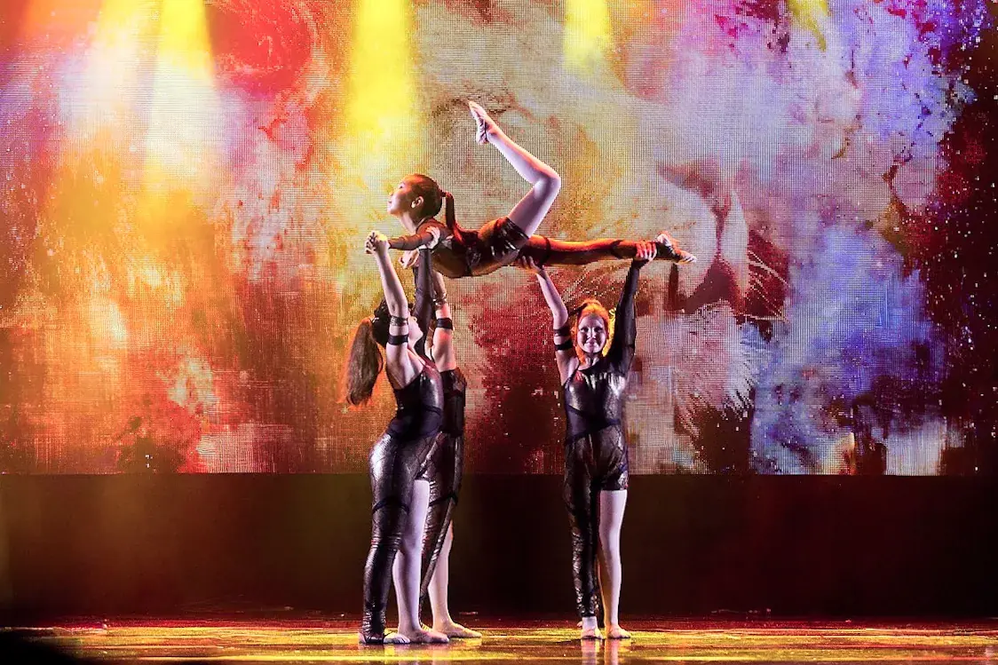 Dancers in a contemporary lift on stage